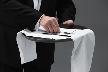 Image showing Senior waiter holding tray