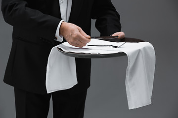 Image showing Senior waiter holding tray