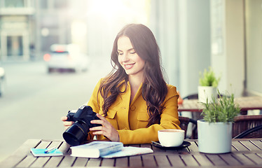 Image showing happy tourist woman with camera at city cafe