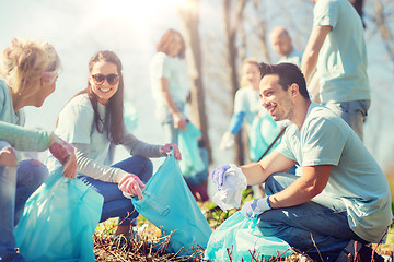 Image showing volunteers with garbage bags cleaning park area