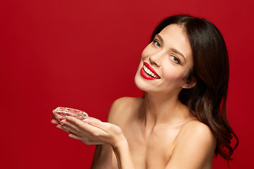 Image showing beautiful woman with red lipstick holding diamond