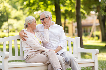 Image showing happy senior couple sitting on bench at park