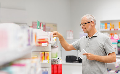 Image showing senior male customer with drug at pharmacy