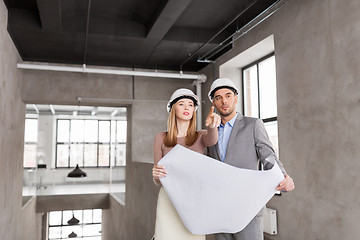 Image showing architects with blueprint and helmets at office