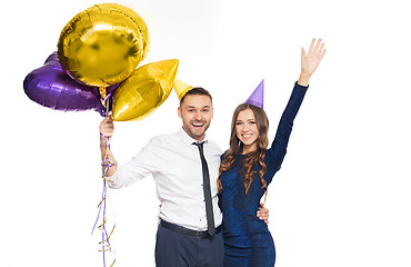 Image showing happy couple with party caps and balloons