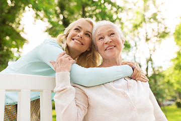 Image showing daughter with senior mother hugging on park bench