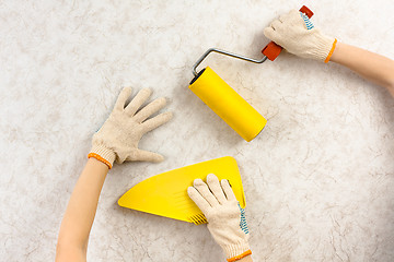 Image showing hands smoothing wallpaper