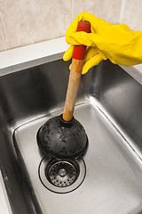 Image showing hand in glove using a plunger