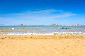Image showing European sandy beach, boat and blue sea.