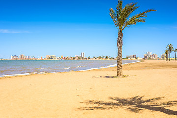 Image showing European sandy beach, boat and blue sea.