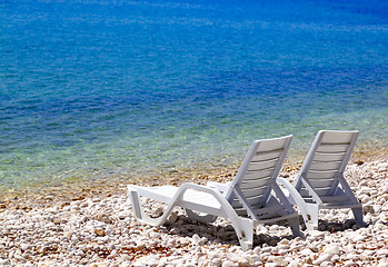 Image showing Two deck chairs on beach in sunny summer day