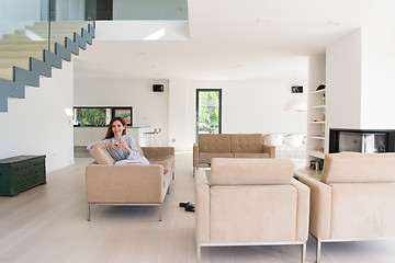 Image showing young woman in a bathrobe enjoying morning coffee