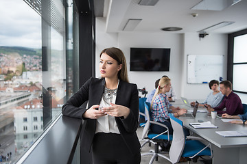 Image showing Business Girl Standing In A Modern Building Near The Window With