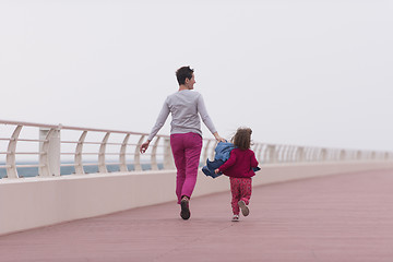 Image showing mother and cute little girl on the promenade by the sea