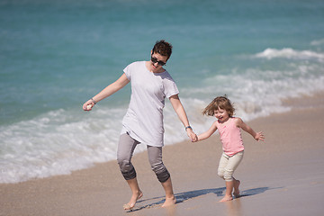 Image showing mother and daughter running on the beach