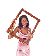 Image showing Smiling woman looking trough picture frame