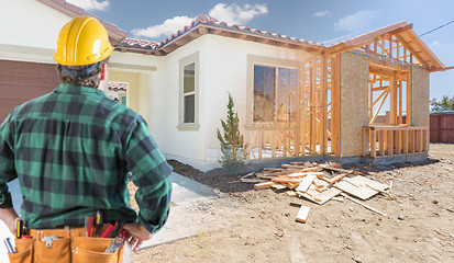 Image showing Contractor Standing Outside Construction Framing and Photo of Ne