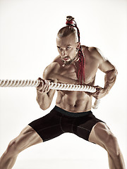 Image showing Attractive muscular man working out with heavy ropes.