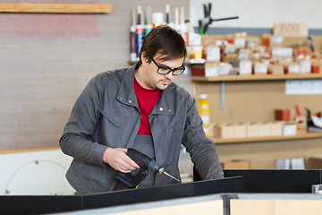 Image showing assembler with screwdriver making furniture