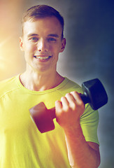 Image showing smiling man with dumbbell in gym