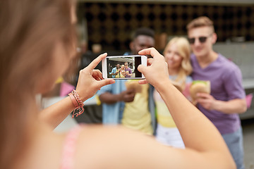 Image showing woman photographing friends eating at food truck