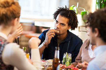 Image showing man with friends eating at restaurant