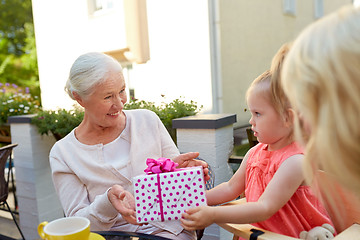 Image showing granddaughter giving present to grandmother