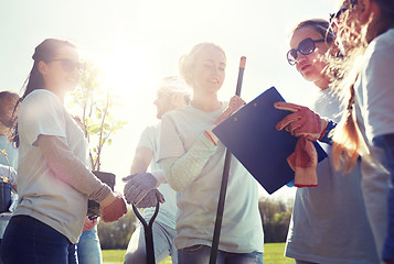 Image showing group of volunteers with tree seedlings in park