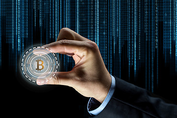 Image showing close up of businessman hand with bitcoin hologram