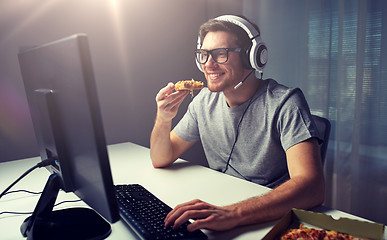 Image showing man in headset playing computer video game at home