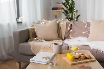 Image showing tea with lemon, book and cookies on table at home