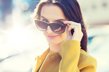 Image showing smiling young woman with sunglasses in city