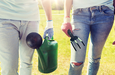 Image showing volunteers with watering can and weeding rake