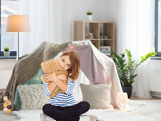 Image showing cute little girl hugging teddy bear at home