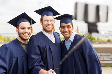 Image showing happy male students taking picture by selfie stick