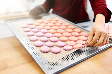 Image showing chef with macarons on oven tray at confectionery