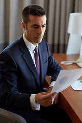 Image showing businessman with papers working at hotel room