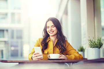 Image showing happy woman texting on smartphone at city cafe