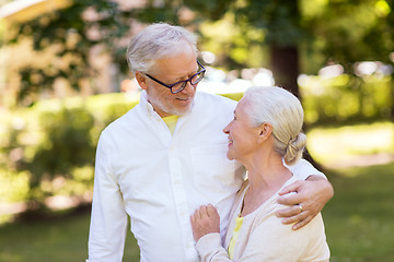 Image showing happy senior couple hugging at summer park