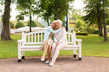 Image showing daughter with senior mother hugging on park bench