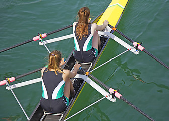 Image showing Two young women rowing race in lake