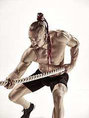 Image showing Attractive muscular man working out with heavy ropes.