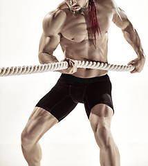 Image showing Attractive muscular man working out with heavy ropes.