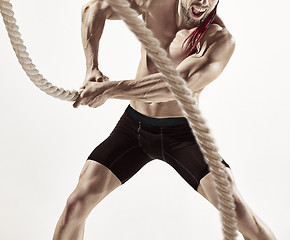 Image showing Attractive muscular man working out with heavy ropes.