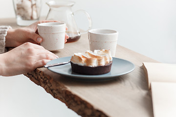 Image showing Cup of coffee, branch of tree, wooden windowsill