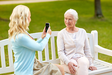 Image showing daughter photographing senior mother by smartphone