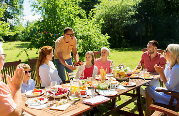 Image showing family having dinner or barbecue at summer garden