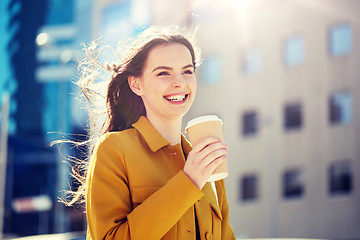 Image showing happy young woman drinking coffee on city street