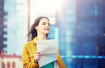 Image showing happy young woman traveling with map in city