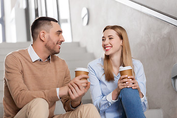 Image showing man and woman with coffee talking at office stairs